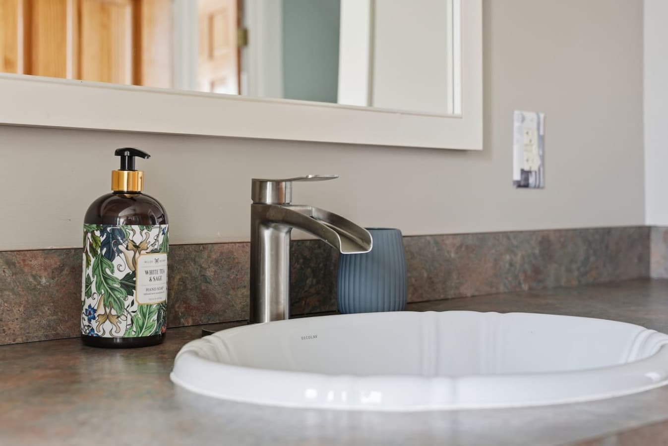 Modern sink with clean counter space and essentials provided.