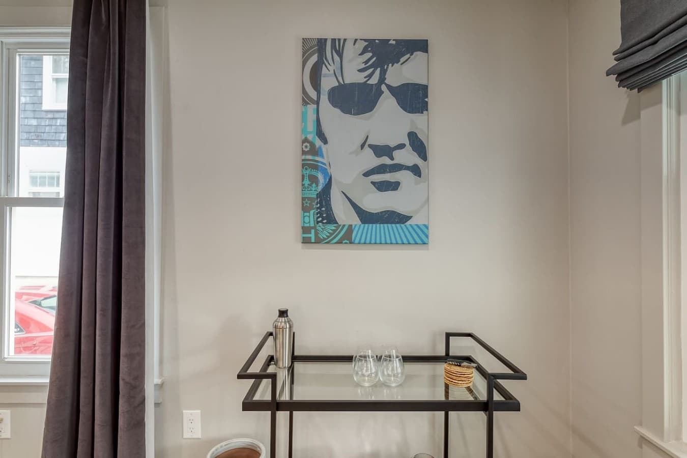 Stylish bar cart area with glassware and unique modern artwork accents.