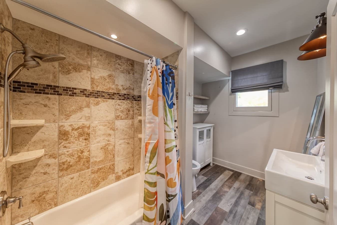 Bright bathroom with a full tub, fresh towels, and added storage space.