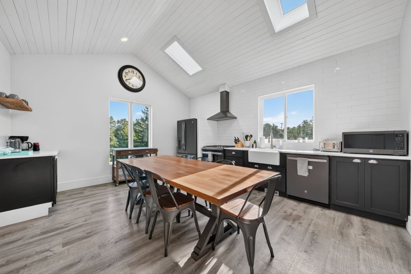 Fully equipped kitchen featuring modern appliances and a large dining table.
