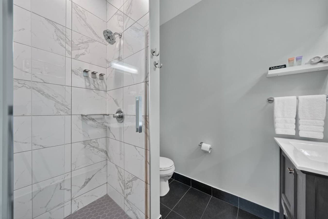 A spotless full bathroom with modern finishes and plenty of space.
