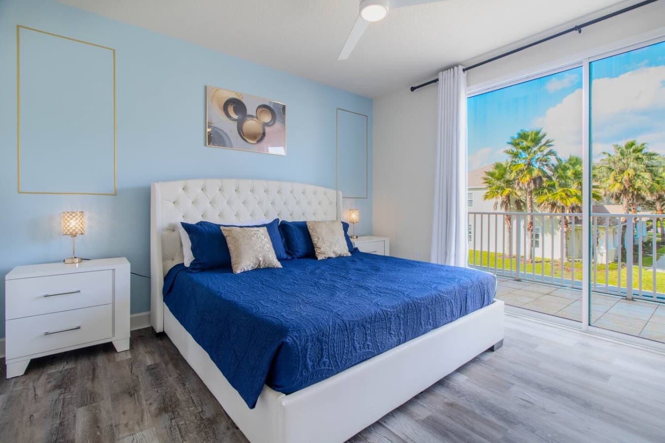 Bright primary bedroom with large sliding glass doors and scenic outdoor views.