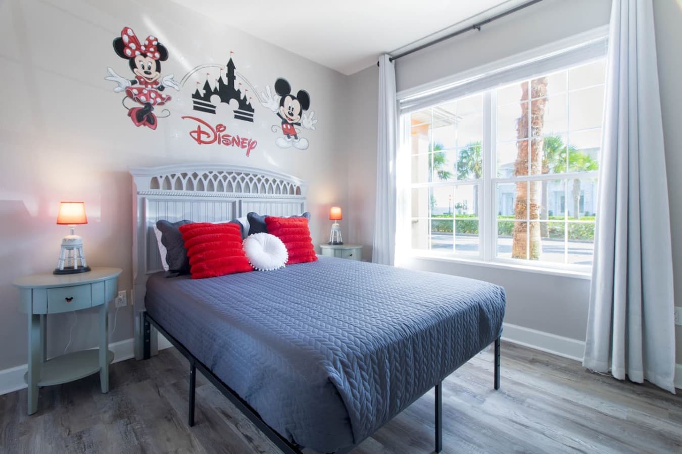 Bright and inviting bedroom featuring large windows and playful decorative accents.