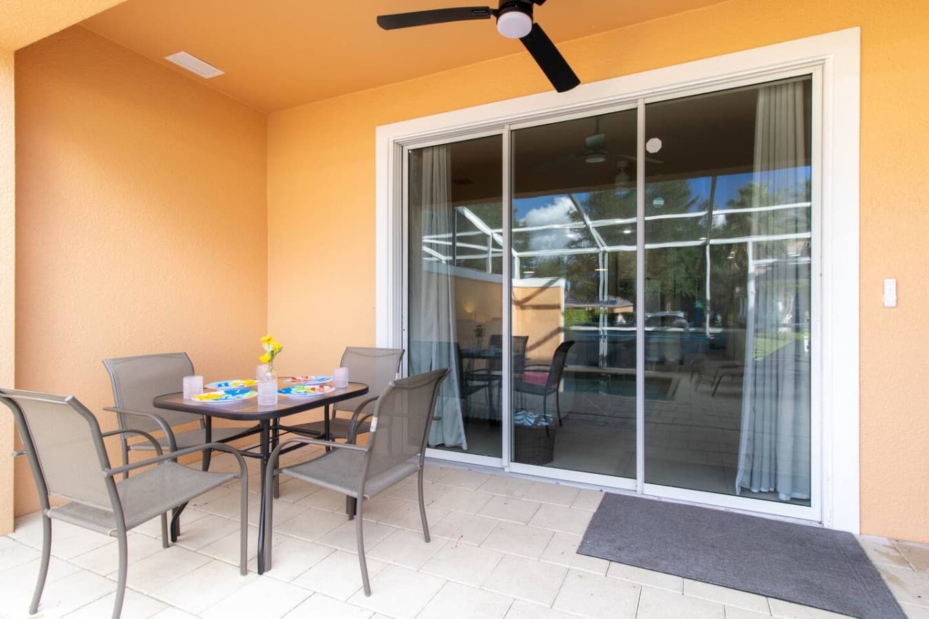 Covered outdoor patio with comfortable seating and a ceiling fan for year round enjoyment.