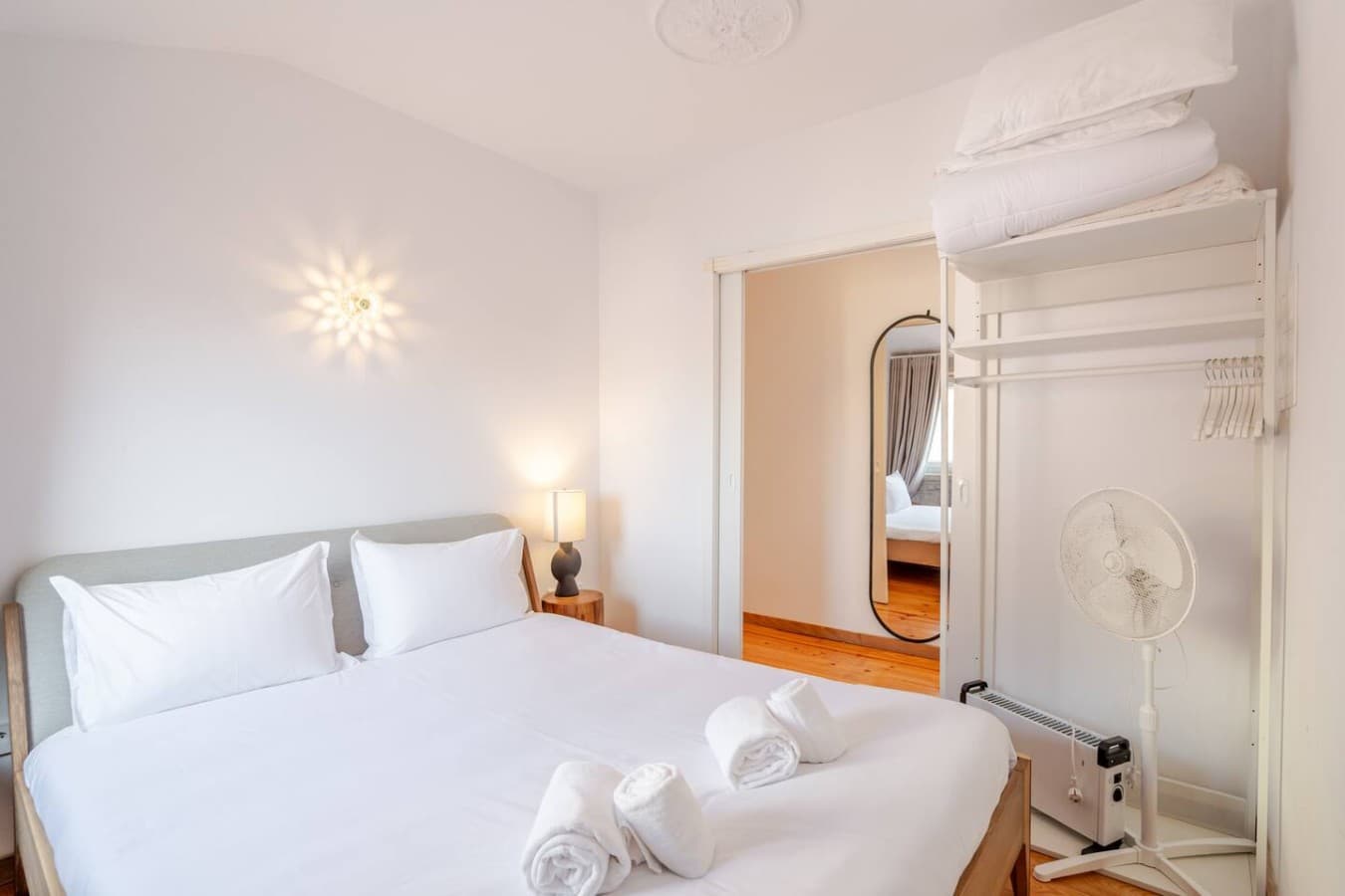 A peaceful retreat with soft linens, warm lighting, and thoughtful storage.