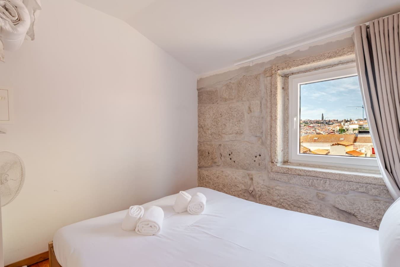 Character meets comfort with a beautiful exposed stone wall and cozy bed.