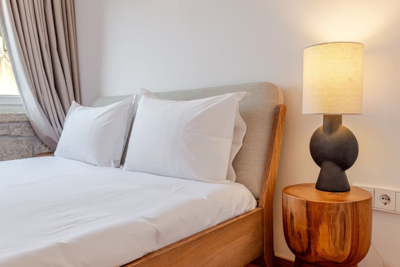A stylish bedside table and warm lighting create the perfect reading nook.