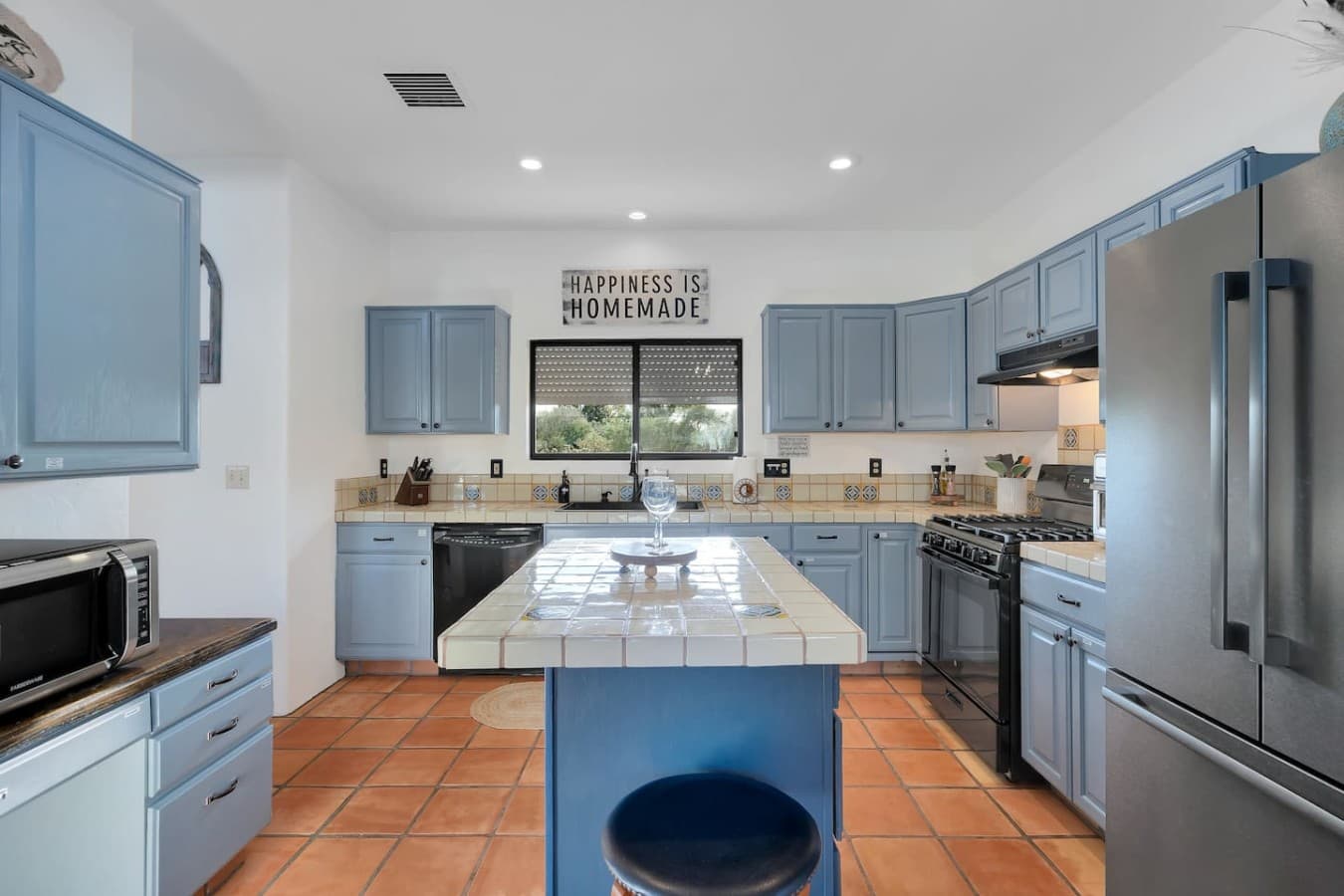 Spacious kitchen with blue cabinetry and a large island for gathering.