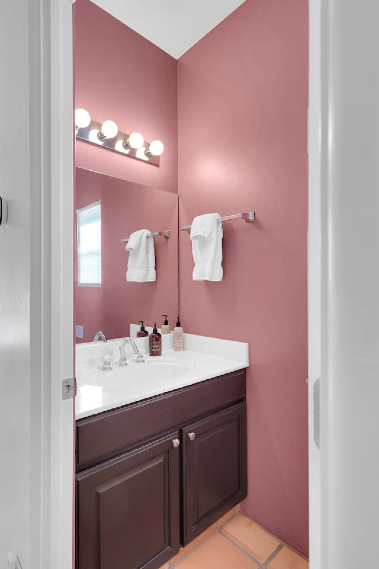 Half bathroom with stylish vanity and bold accent walls.
