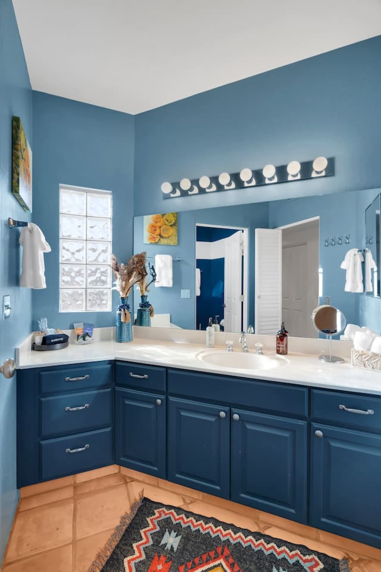 Stylish bathroom with blue cabinetry and a spacious vanity.