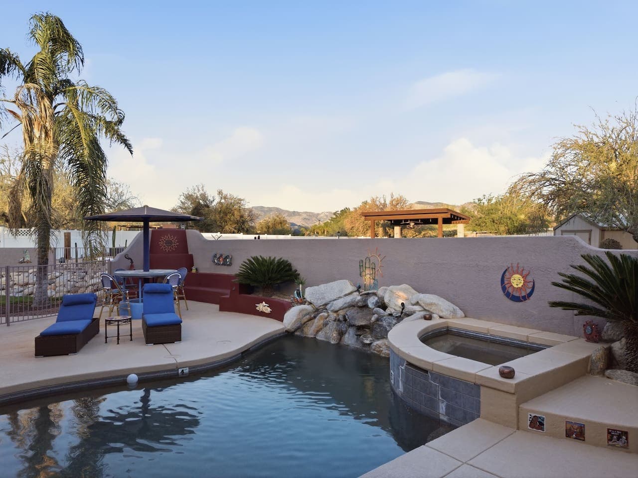 Beautiful pool with waterfall feature and surrounding patio seating.