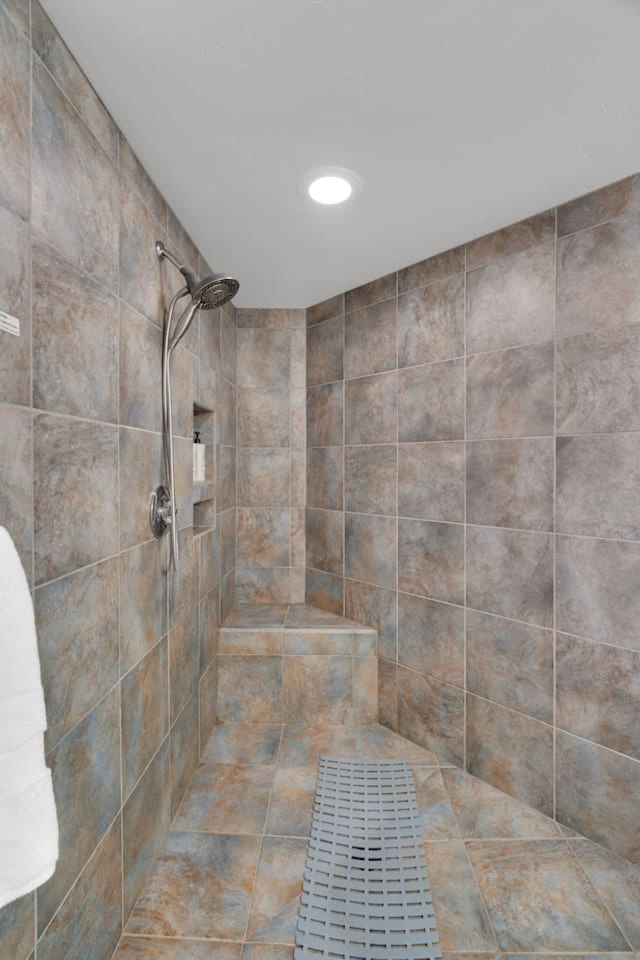 Tiled walk in shower with built in seating for added comfort.