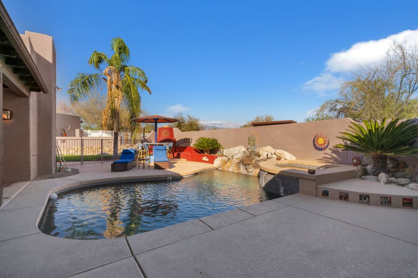 Spacious pool area with sun loungers and vibrant outdoor decor.