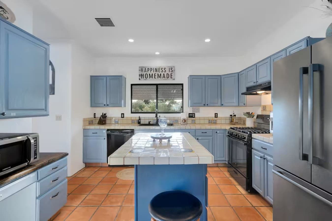 Spacious kitchen with blue cabinetry and a large island for gathering.