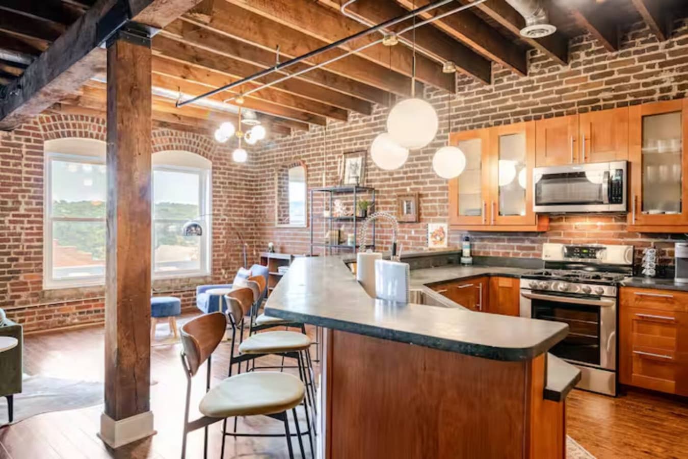 Open kitchen with spacious island seating and exposed brick details.