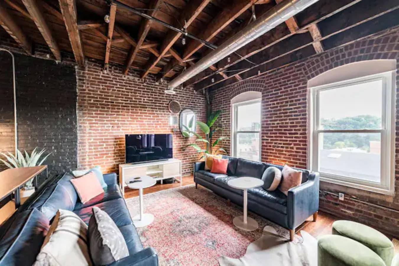 Inviting living area with TV, brick walls, and warm textures.