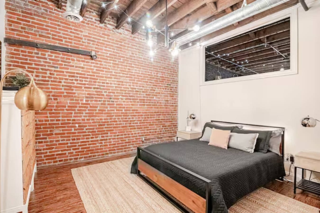 Serene sleeping space with exposed brick and clean modern design.