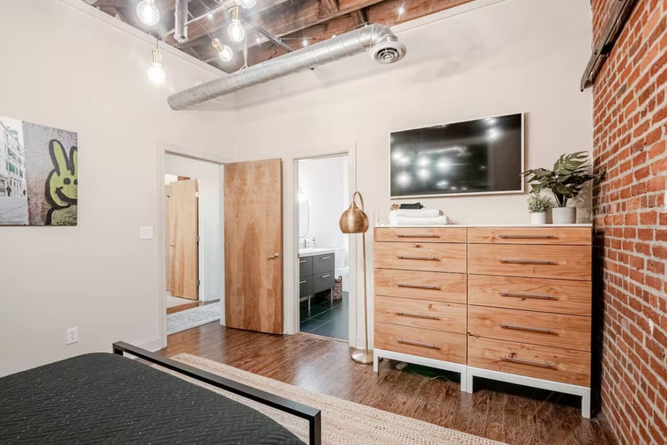 Bedroom view with dresser storage and wall mounted TV.