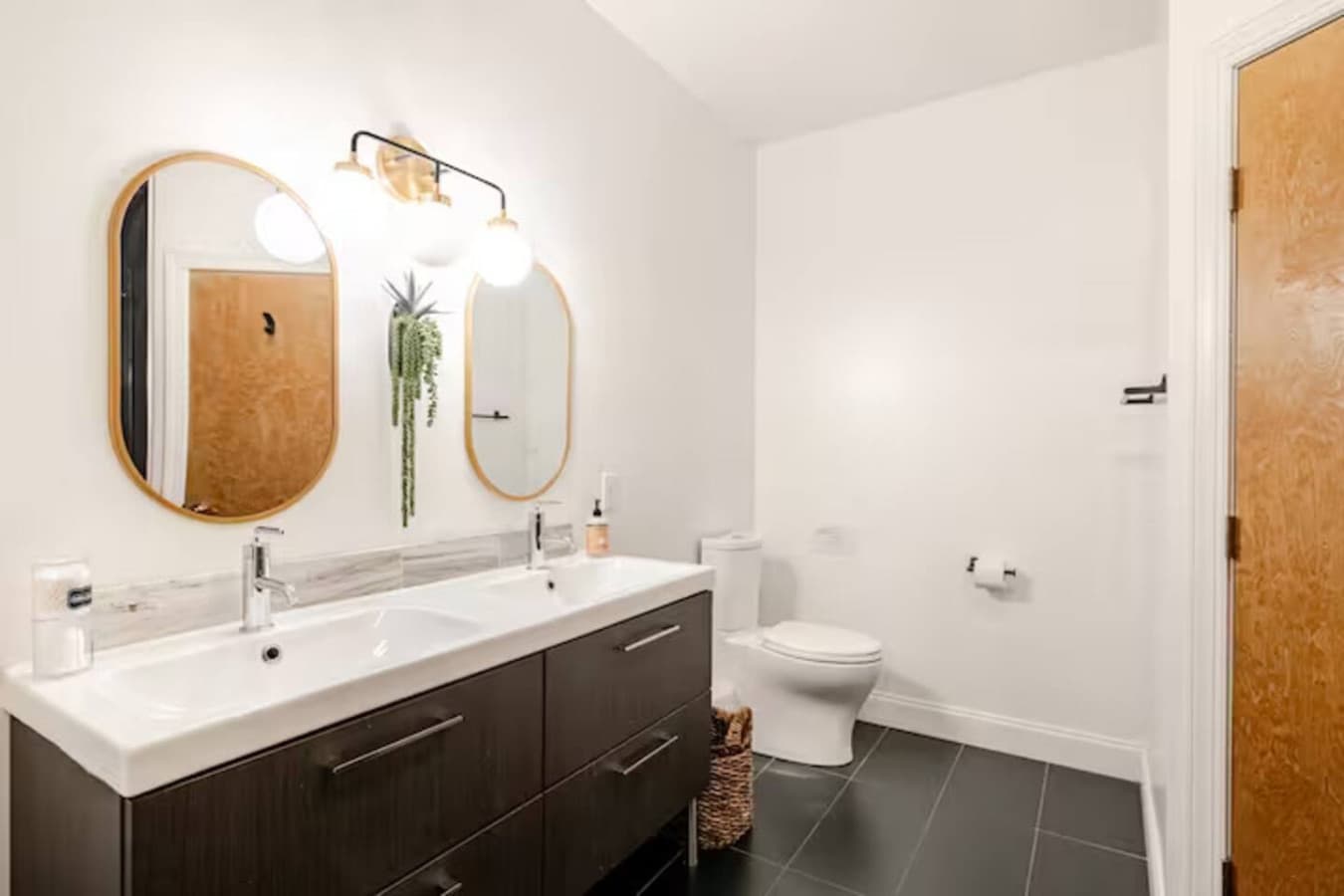 Double sink vanity with modern lighting and finishes.