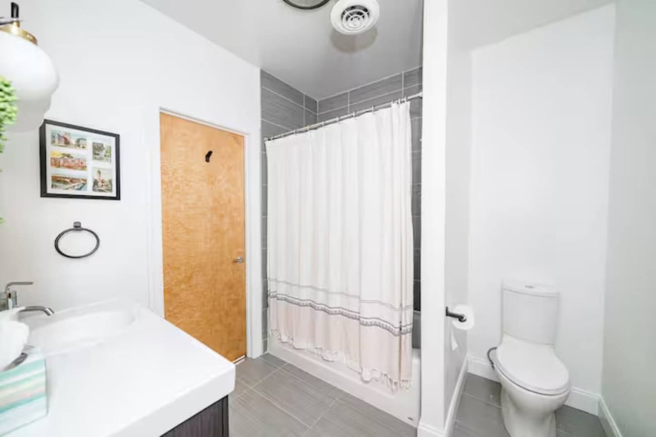 Bathroom with tub and shower combo and clean modern finishes.