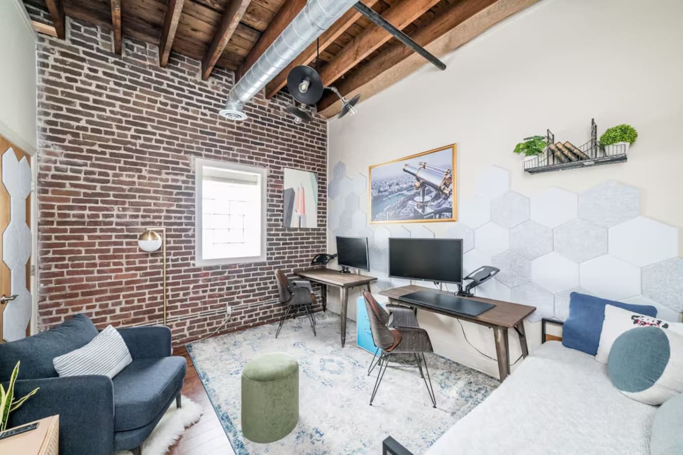 Dedicated workspace with desk, seating, and exposed brick accents.