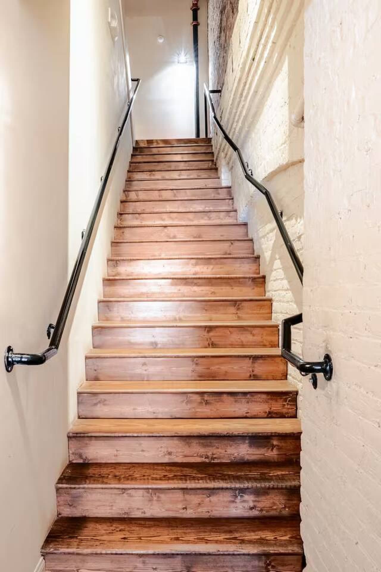 Wooden staircase with handrails and classic loft character.