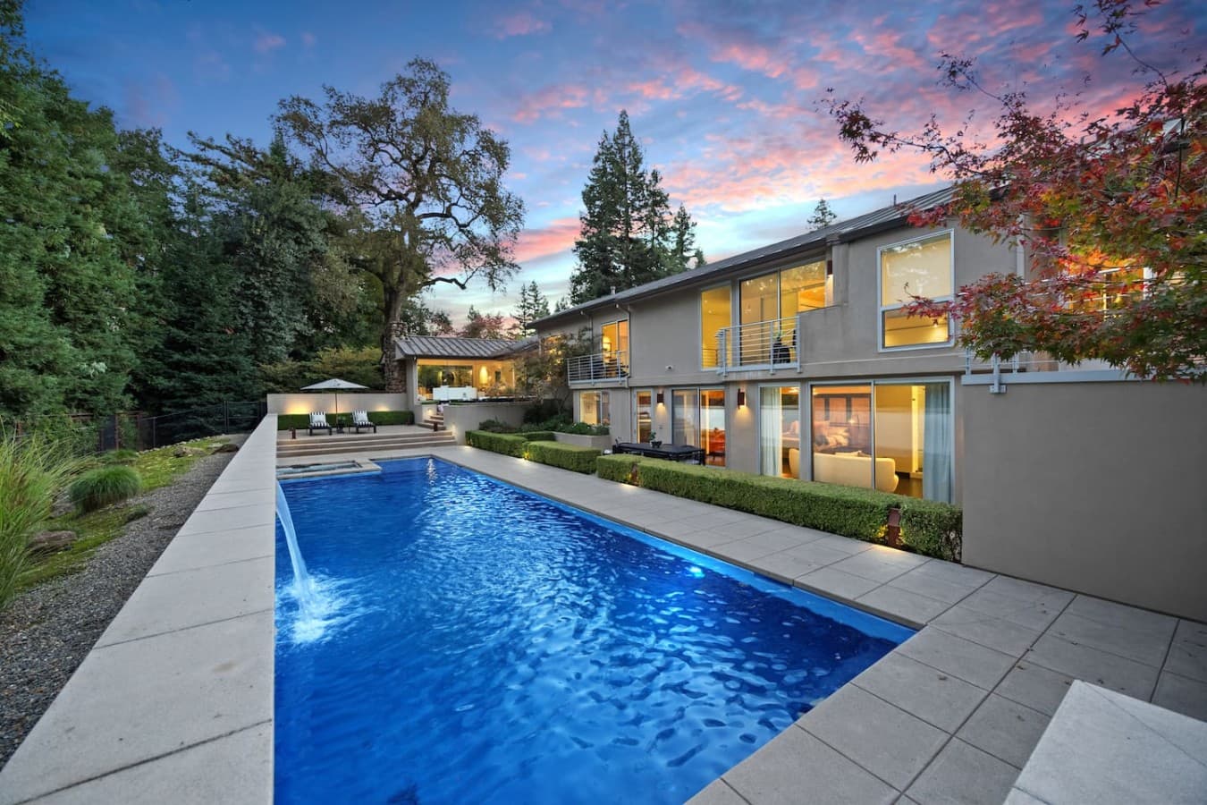 Resort style pool surrounded by beautifully landscaped grounds and elegant outdoor living spaces.
