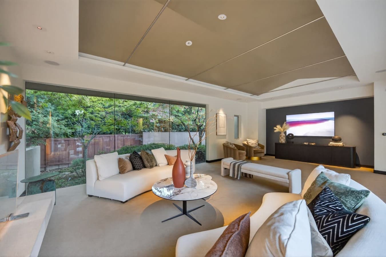 Elegant sitting room with oversized windows that frame lush garden views and fill the space with natural light.