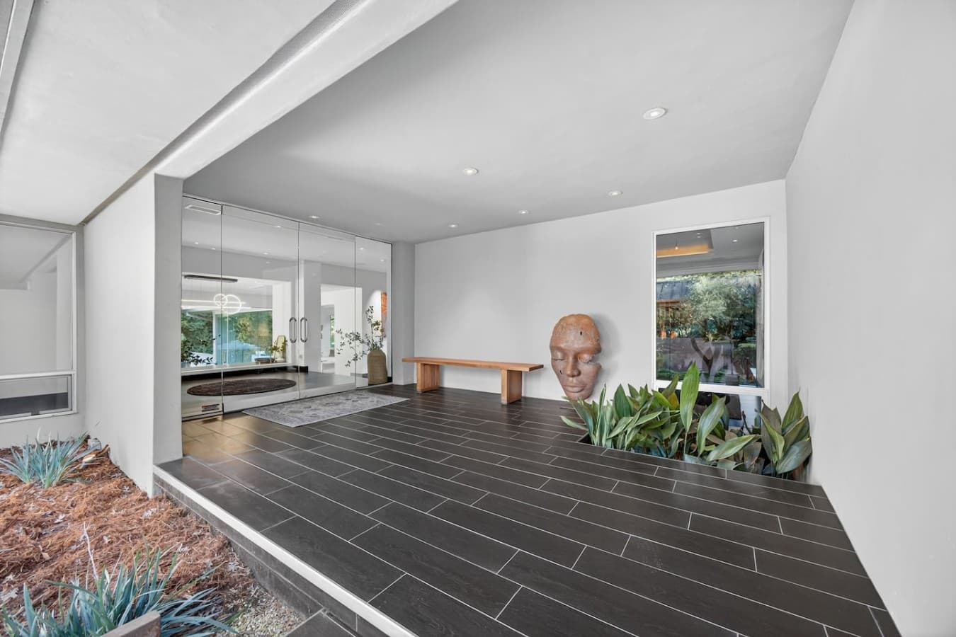 Striking entry foyer with clean architectural lines, curated design details, and a seamless connection to the outdoor living spaces.