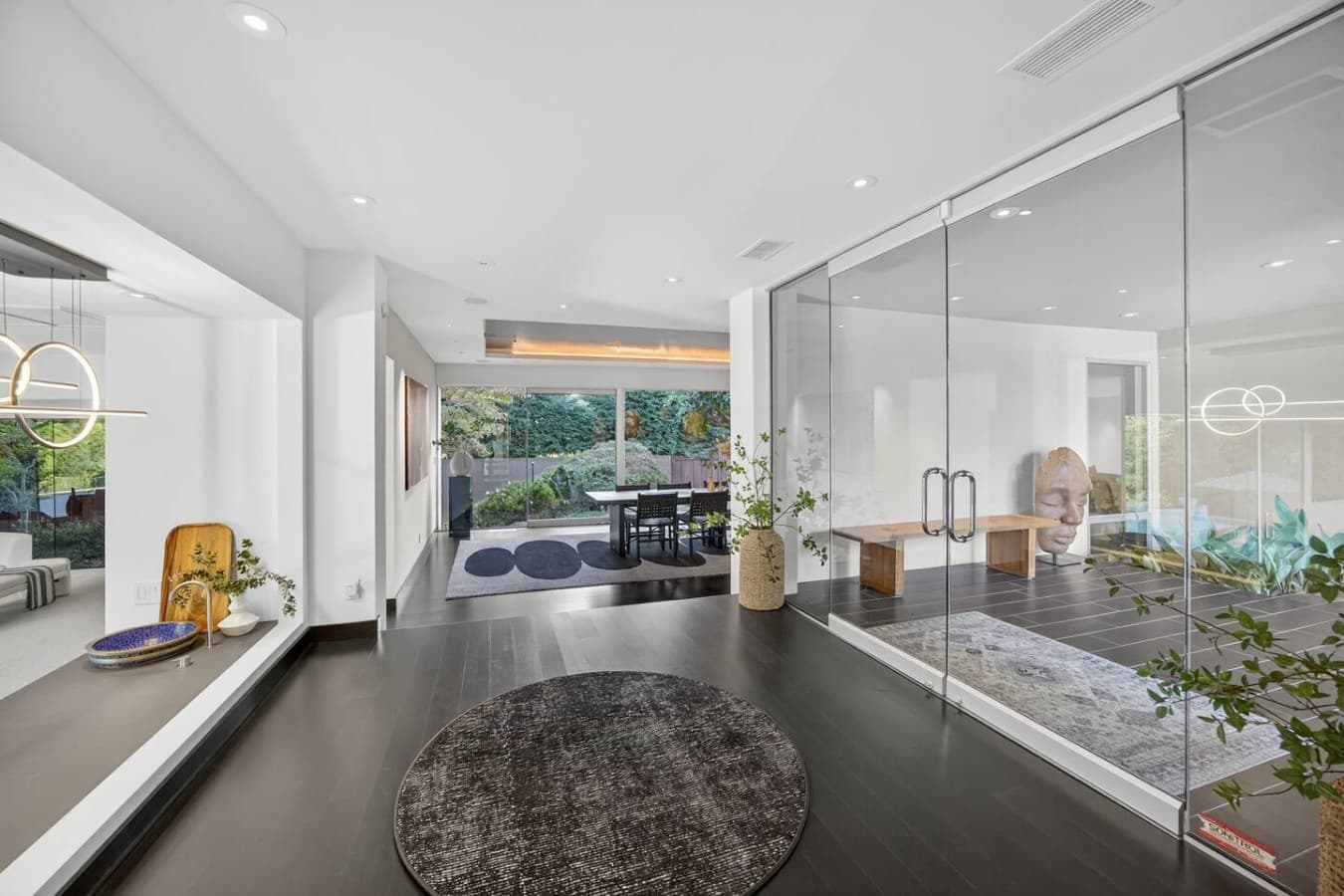 Grand welcoming entrance featuring floor to ceiling glass, abundant natural light, and views through the heart of the home.