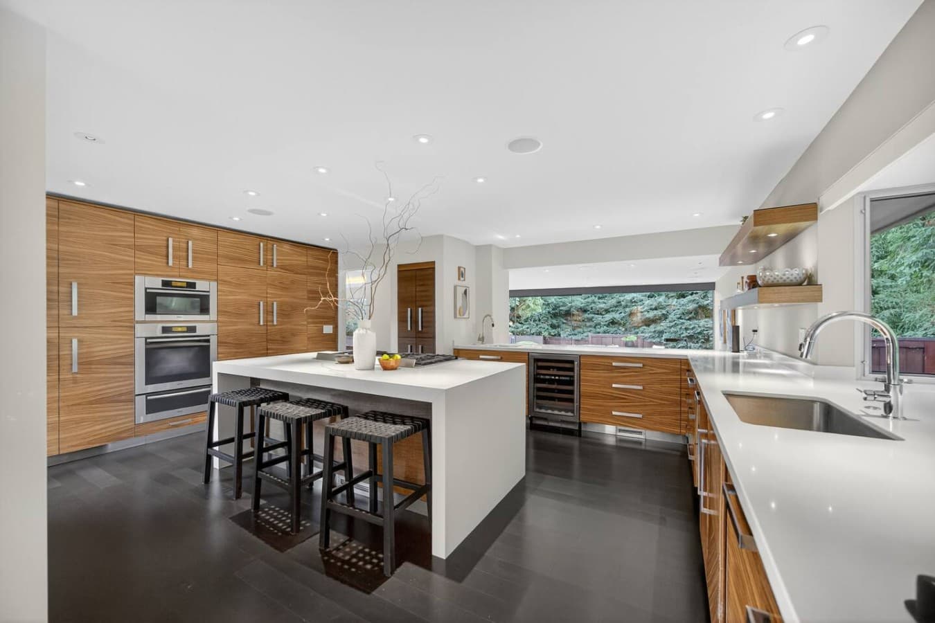 Chef inspired kitchen with a large waterfall island, premium appliances, and generous space for gathering.