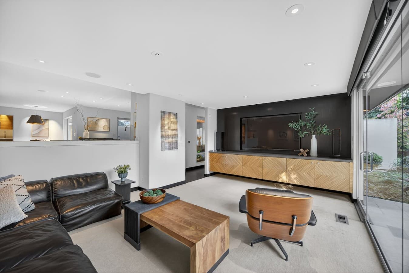 Modern open concept living area featuring custom finishes and a sophisticated media wall.