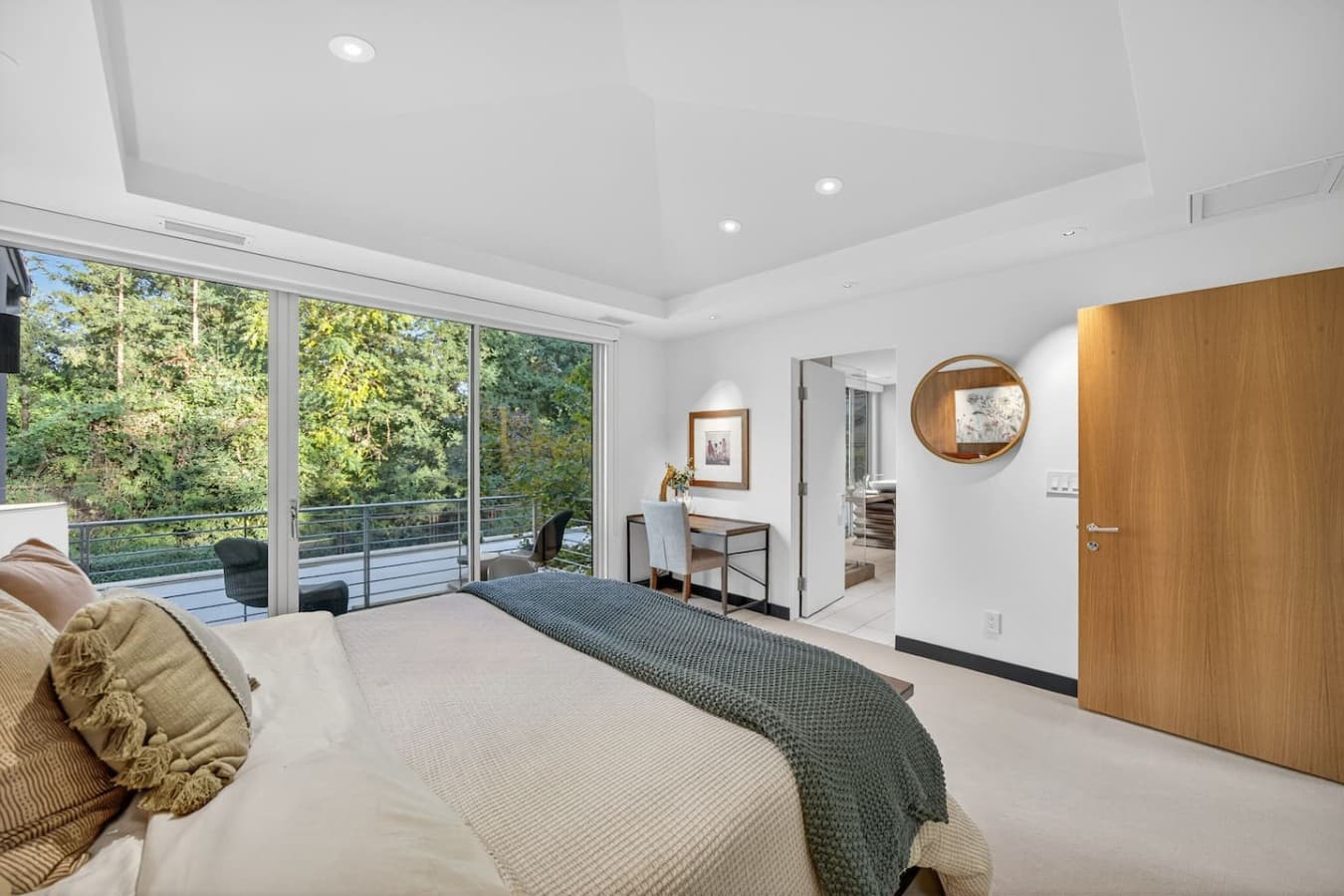 Bright and airy bedroom retreat with floor to ceiling windows and peaceful views of the surrounding greenery.
