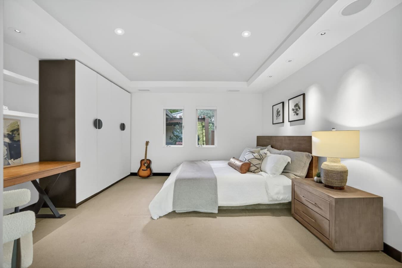 Comfortable guest bedroom featuring a plush bed, soft neutral tones, and a bright, relaxing atmosphere.