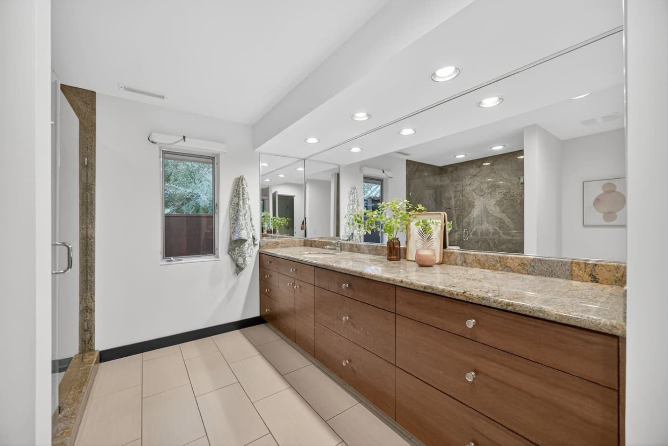 Spacious bathroom with a double vanity, extensive counter space, and elegant natural stone finishes.