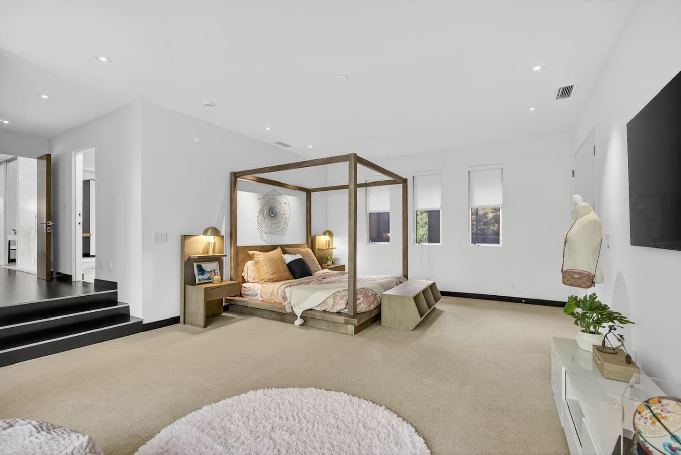 Spacious bedroom retreat featuring a statement canopy bed, soaring ceilings, and a calming contemporary design.