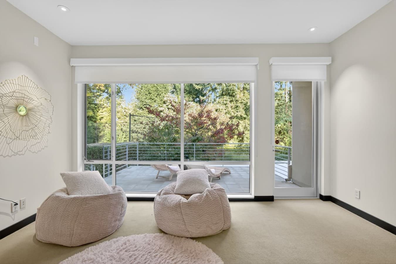 Floor to ceiling glass doors open to a private terrace surrounded by peaceful treetop views.