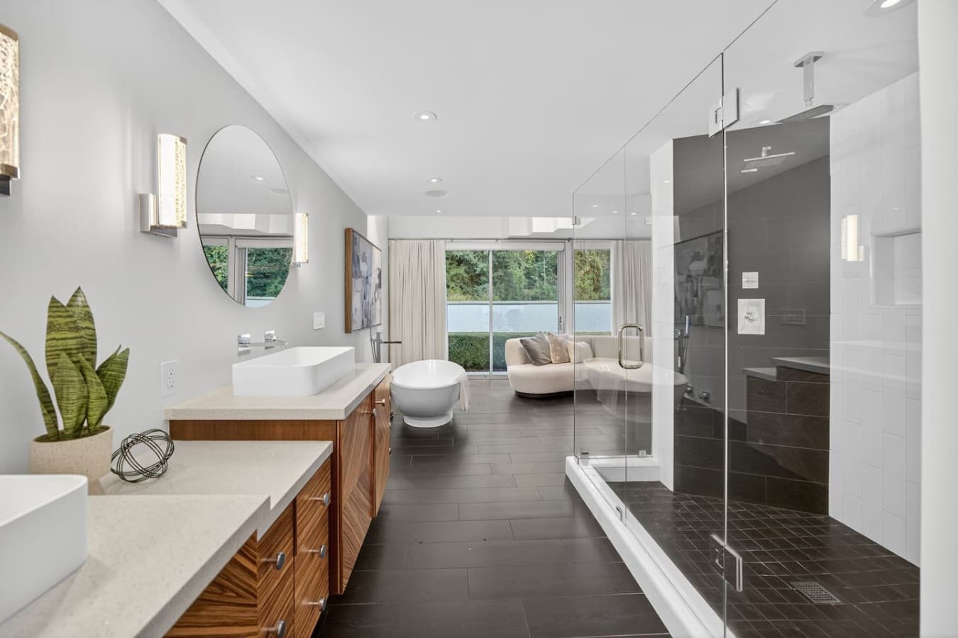 Spa inspired ensuite featuring a freestanding soaking tub, oversized walk in shower, and serene garden views.
