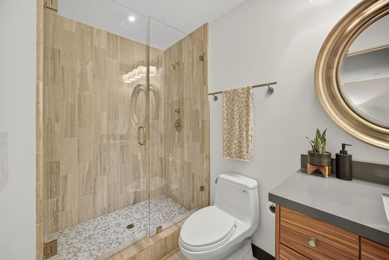 Contemporary bathroom with a glass enclosed shower, elegant tilework, and a clean, spa inspired design.