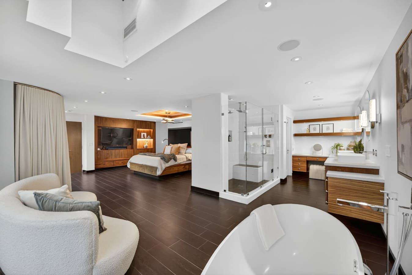 Resort style primary retreat with an open layout, freestanding soaking tub, and beautifully appointed dressing area.
