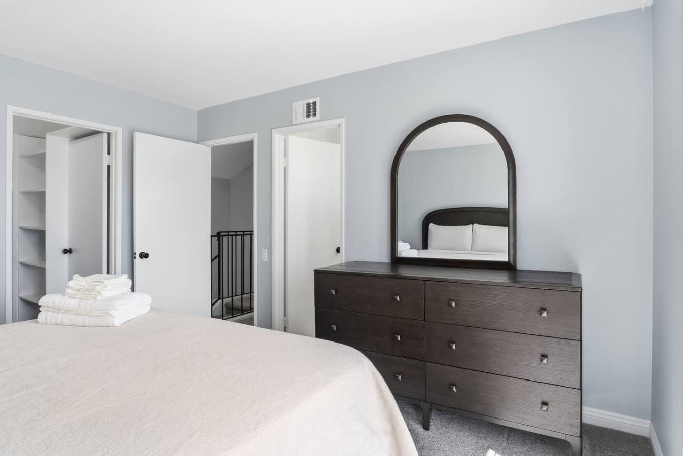 Spacious bedroom with dresser storage and a clean modern design.