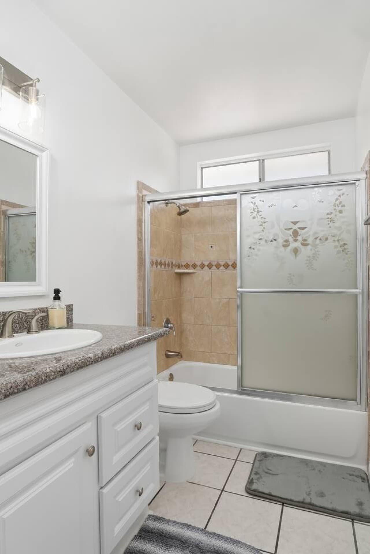 Full bathroom with granite countertops and fresh essentials.