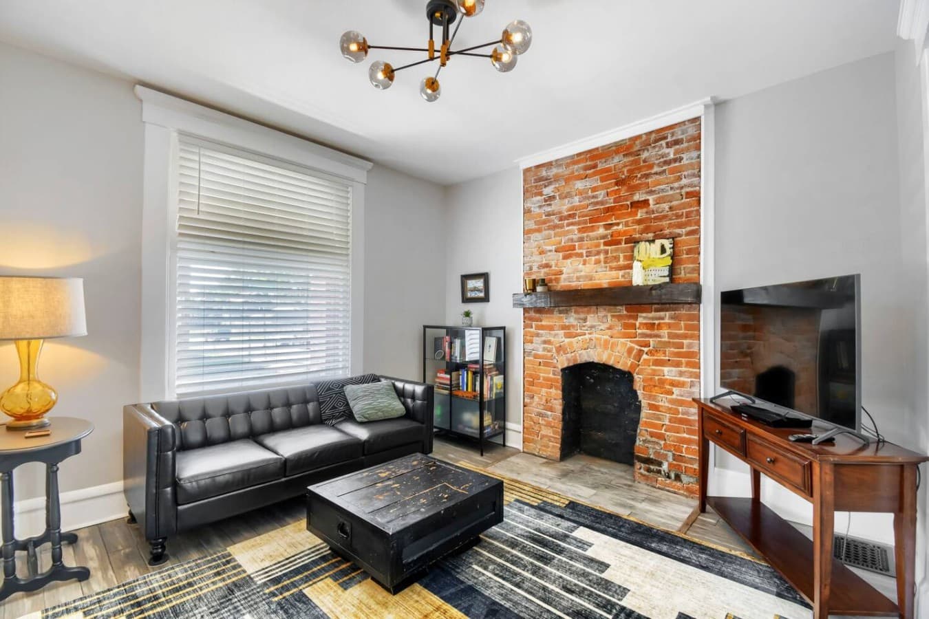 Historic brick fireplace adds character to this inviting living room with comfortable seating and space to relax.