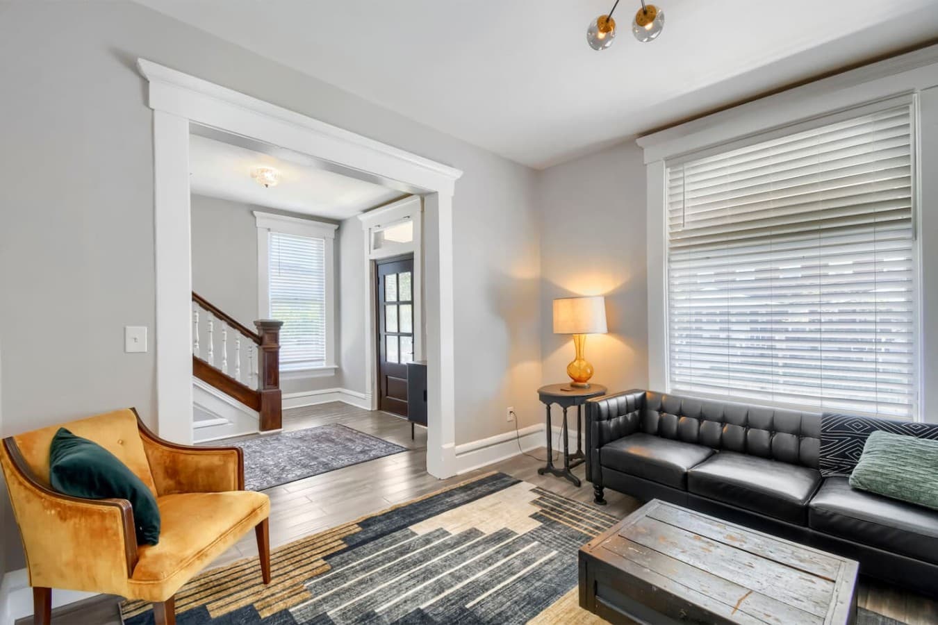 Bright and welcoming living space with comfortable seating and easy access to the entryway and staircase.