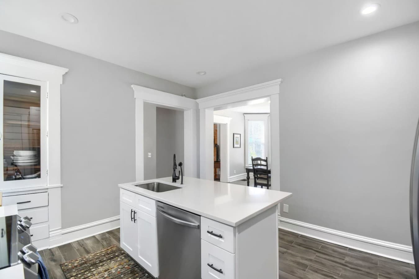Open concept kitchen with a sleek island, dishwasher, and easy access to the dining and living areas.