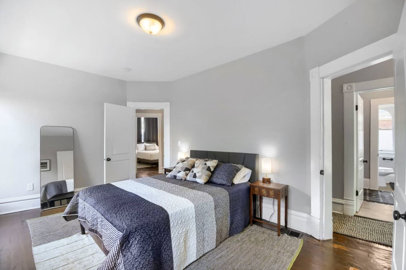 Stylish bedroom with modern furnishings, bedside lighting, and easy access to the adjoining rooms.