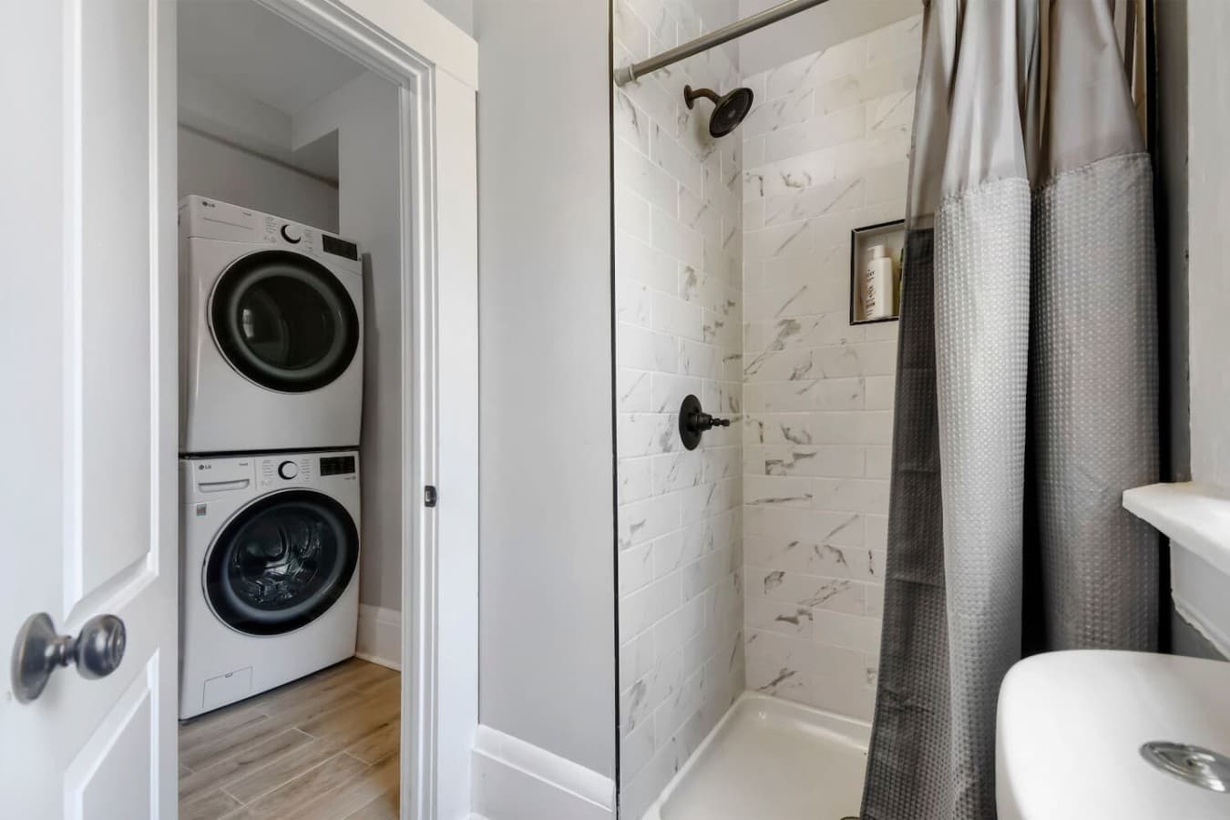 Convenient full bathroom featuring a walk in shower with easy access to the in home washer and dryer.