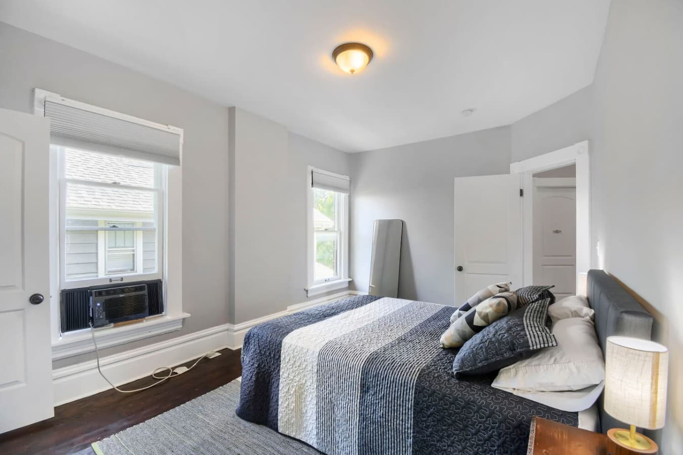 Comfortable bedroom with large windows, cozy bedding, and plenty of natural light for a relaxing stay.