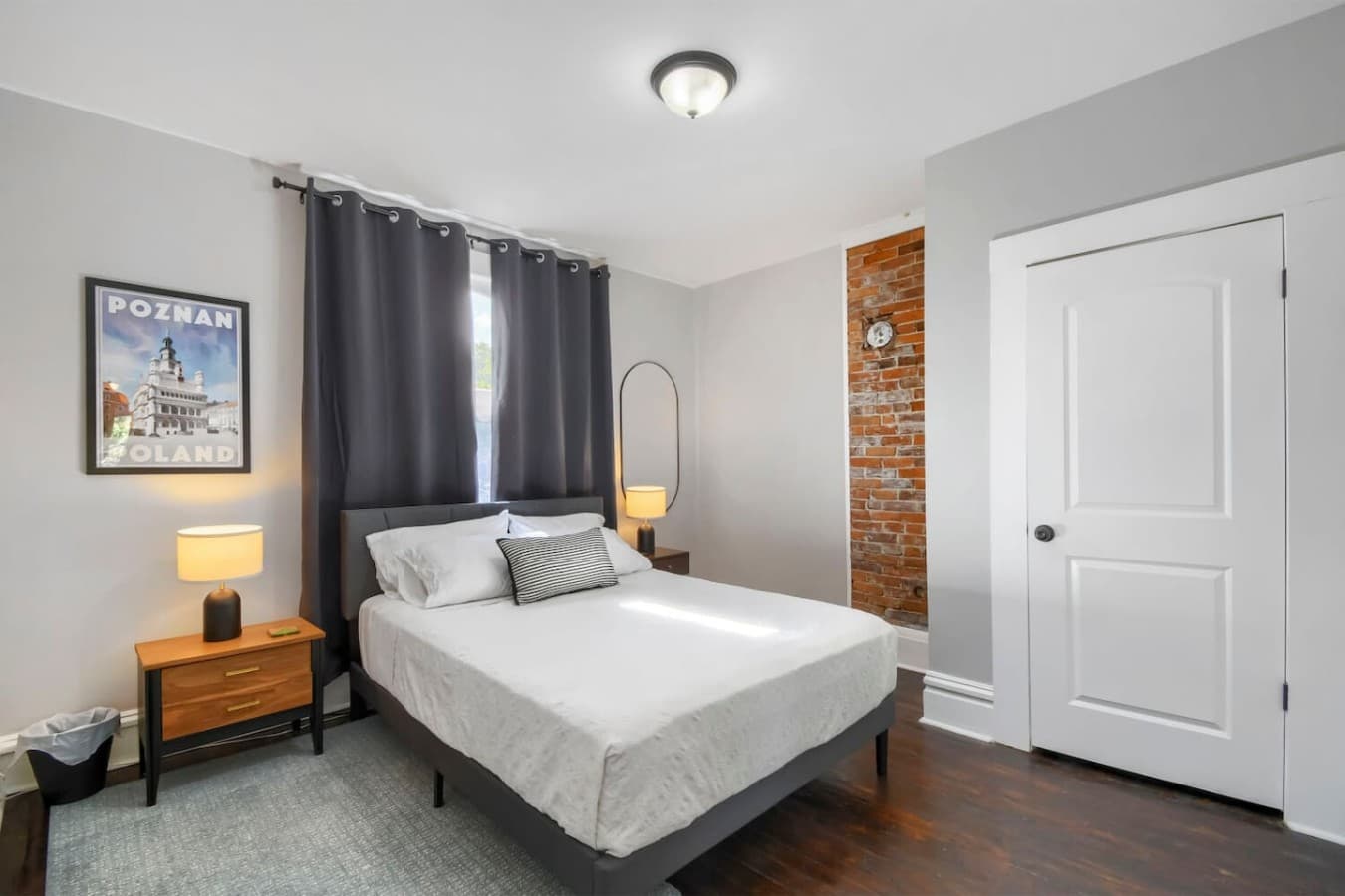 Cozy bedroom with a comfortable bed, exposed brick accents, and soft lighting for a relaxing stay.