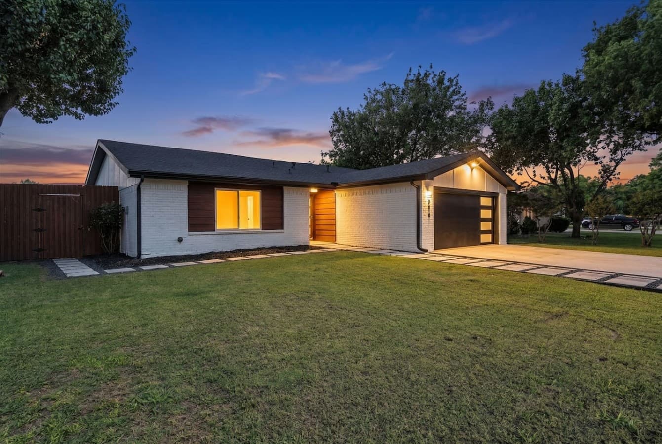 Beautifully illuminated exterior at dusk creating a warm and inviting first impression.